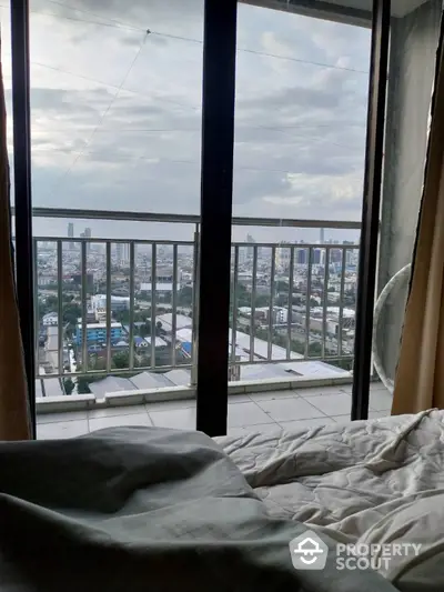 Stunning cityscape view from a cozy bedroom with balcony access.