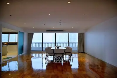 Spacious living room with polished wooden floors and city view balcony.
