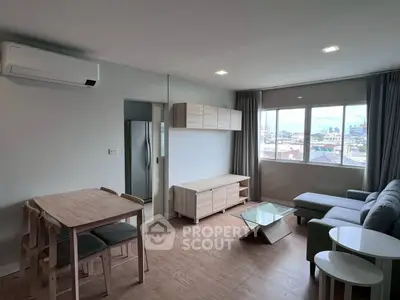 Modern living room with city view, featuring sleek furniture and natural light.