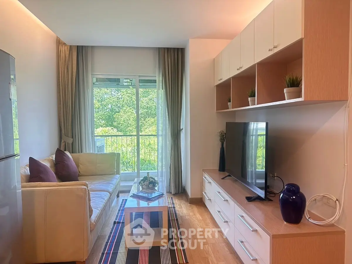 Modern living room with large window, cozy sofa, and stylish entertainment unit.