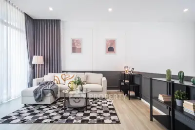 Modern living room with stylish decor, large windows, and cozy seating area.