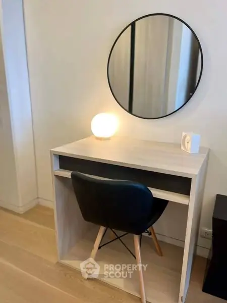 Modern study nook with sleek desk, chair, and round mirror in stylish home interior.