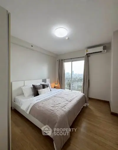 Modern bedroom with large window and city view, featuring cozy bed and stylish decor.