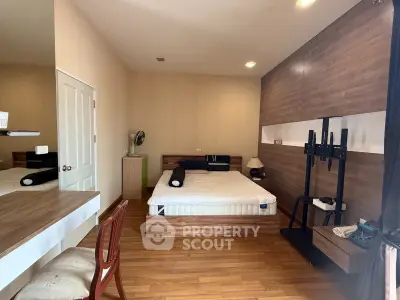 Cozy bedroom with wooden flooring and modern decor, featuring a comfortable bed and stylish furnishings.