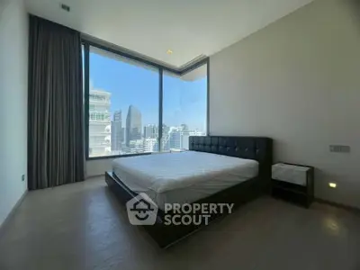 Spacious bedroom with stunning city view and modern design in high-rise apartment.