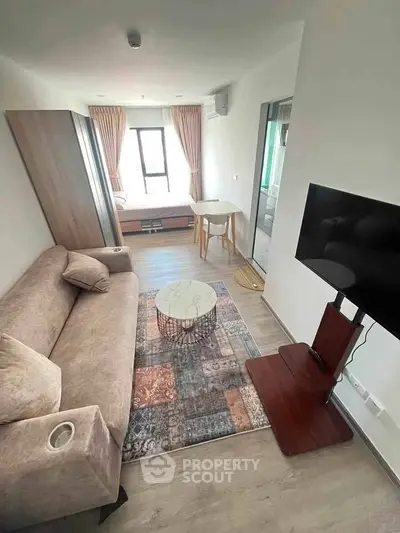 Modern living room with stylish decor, cozy sofa, and wall-mounted TV in a bright apartment.