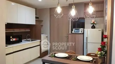 Modern kitchen with dining area, stylish lighting, and contemporary appliances.