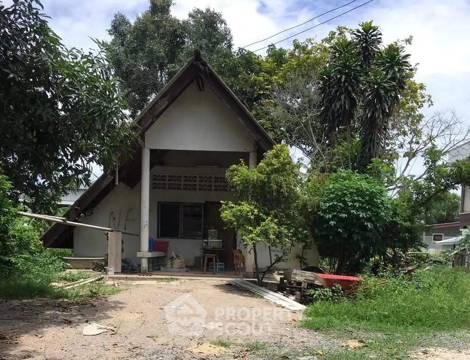 Charming rustic house with lush greenery and unique architectural design.