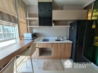 Modern kitchen with sleek black fridge and built-in stove, featuring a cozy breakfast bar by the window.