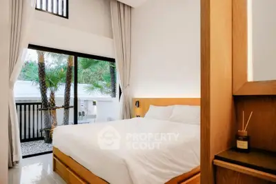 Modern bedroom with large window and garden view, featuring sleek wooden furniture and elegant decor.