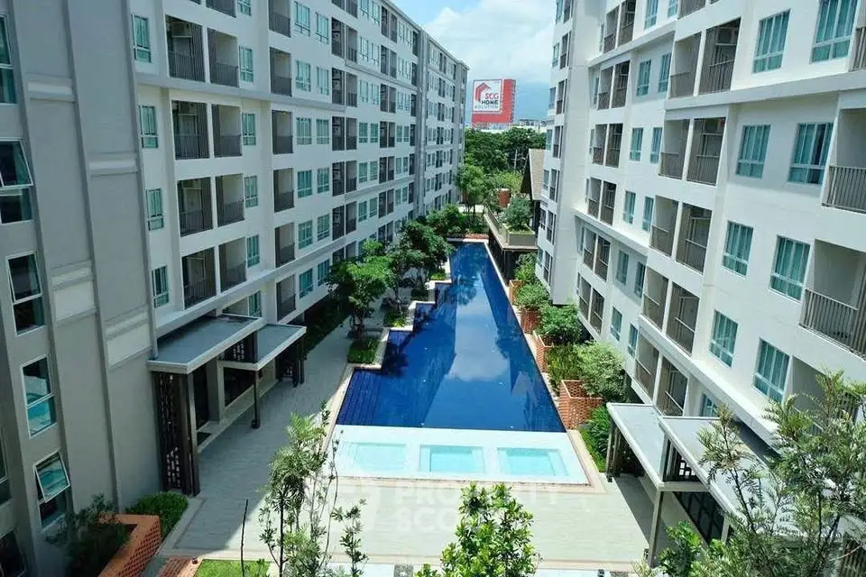 Modern apartment complex with central swimming pool and lush greenery.