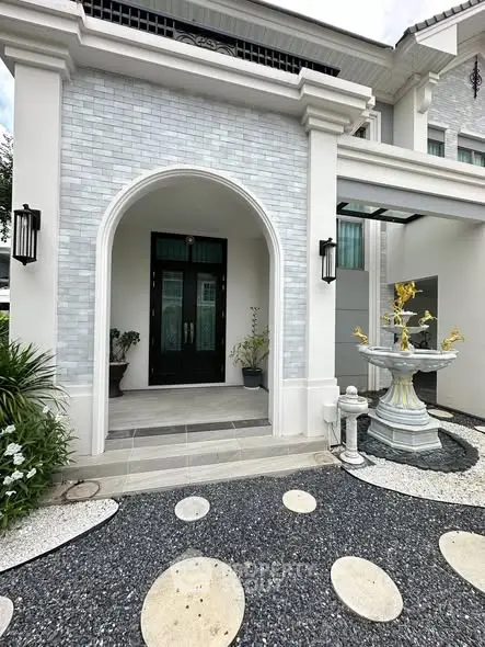Elegant entrance of luxury home with stylish archway and decorative fountain