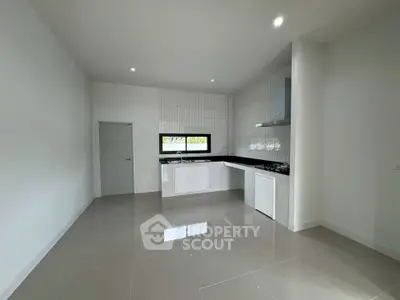 Modern kitchen with sleek white cabinets and glossy tiled floor