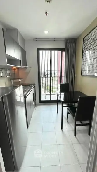 Modern kitchen with sleek appliances and dining area in a compact layout