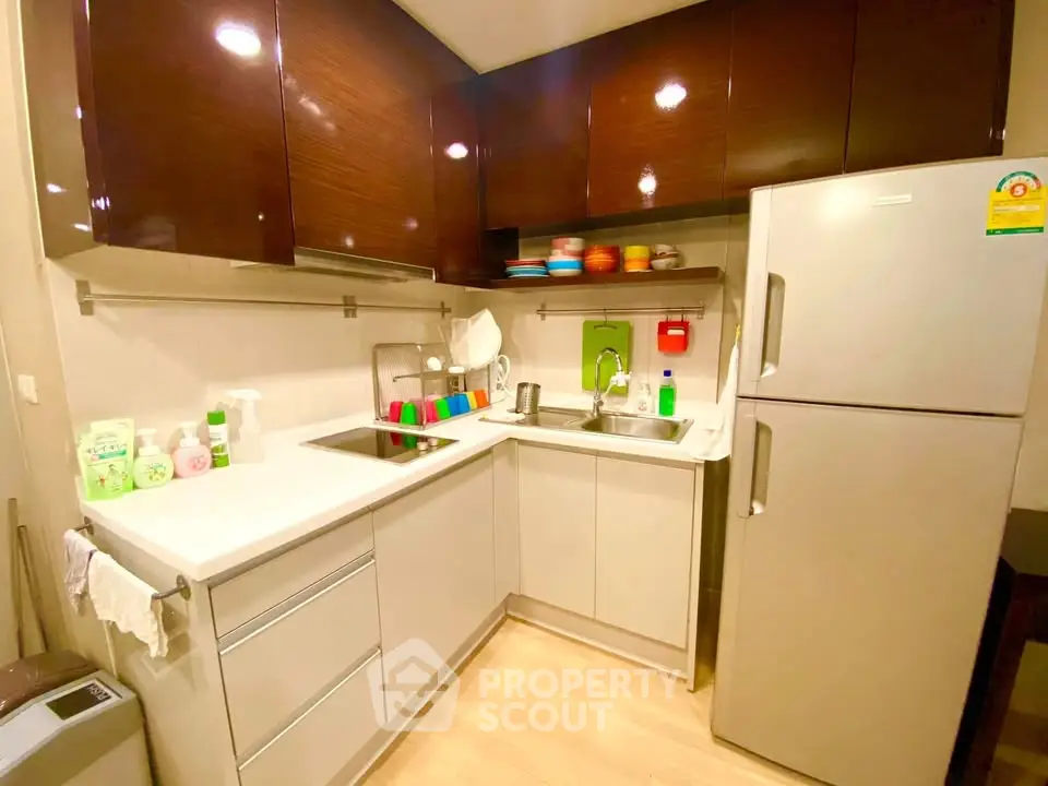 Modern kitchen with sleek cabinets and stainless steel fridge in cozy apartment
