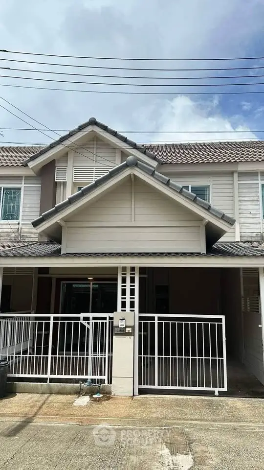Charming townhouse with modern facade and gated entrance in a serene neighborhood.
