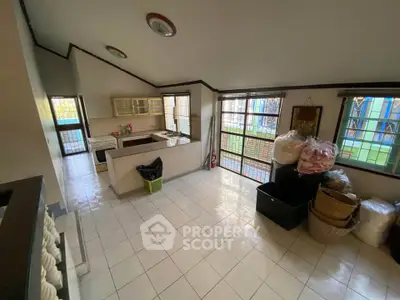 Spacious kitchen with open layout and ample natural light, featuring tiled flooring and modern cabinetry.