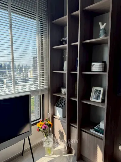 Modern living room with city view, stylish shelving, and natural light.