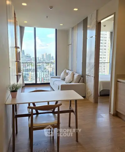 Modern apartment with open living room and city view, featuring elegant decor and natural light.
