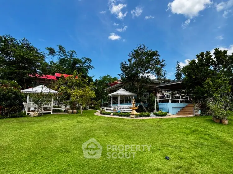 Charming garden view with gazebo and lush greenery under a clear blue sky.