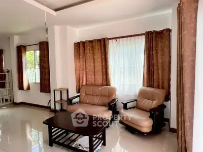 Spacious living room with elegant leather seating and natural light