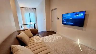 Modern living room with cozy sofa and wall-mounted TV, perfect for relaxation.