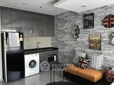 Modern kitchen with washing machine and stylish brick wall decor in cozy apartment.
