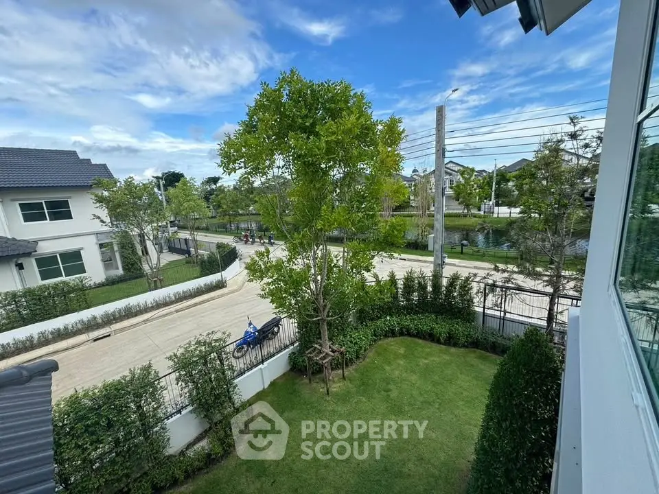 Charming suburban view from a modern home with lush garden and clear blue skies.