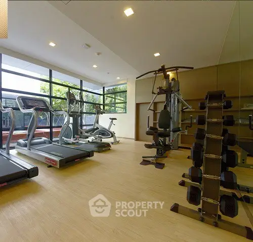 Modern gym with state-of-the-art equipment and large windows for natural light.