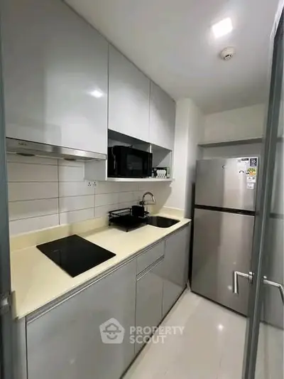 Modern compact kitchen with sleek cabinetry and stainless steel appliances