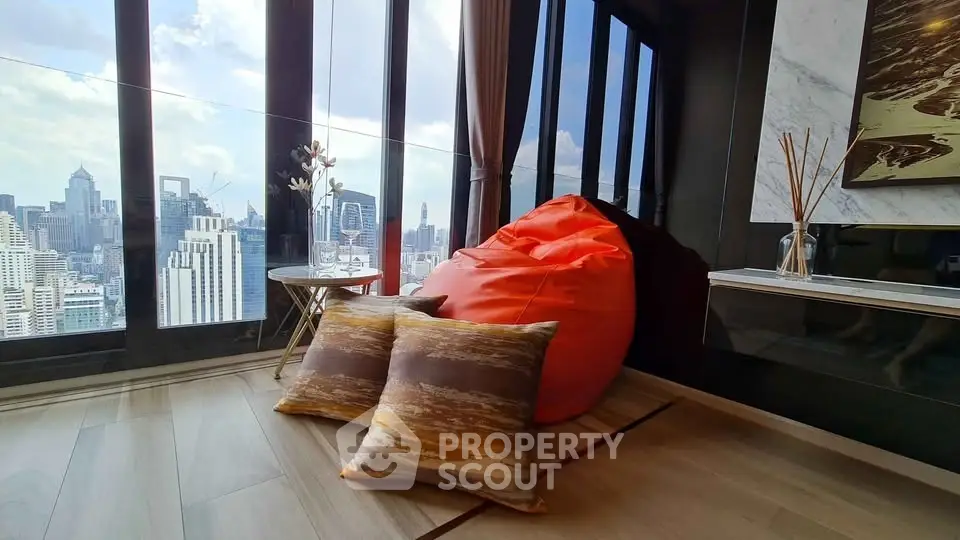 Luxurious high-rise apartment with stunning city view and cozy seating area.