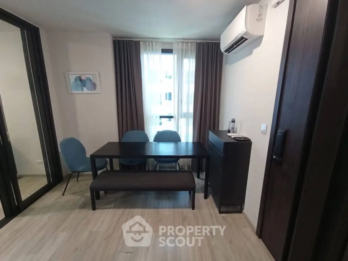 Modern dining area with sleek table and chairs, air conditioning, and stylish decor.