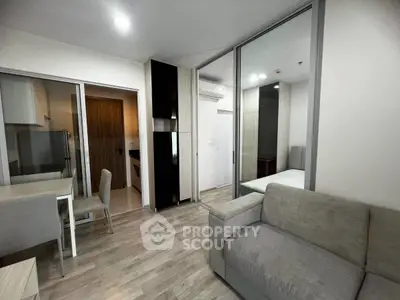 Modern living room with sleek design and open kitchen layout in a stylish apartment.