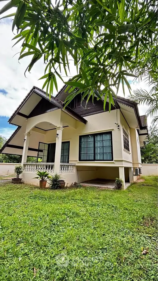 Charming two-story house with lush garden and spacious porch, perfect for family living.