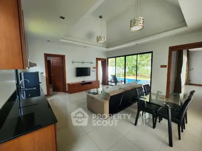 Spacious modern living room with open kitchen and pool view, ideal for luxury living.