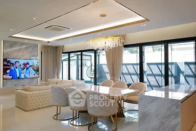 Luxurious open-plan living and dining area with elegant chandelier and modern decor.
