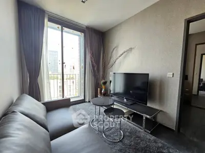 Modern living room with sleek furniture and city view from large window.