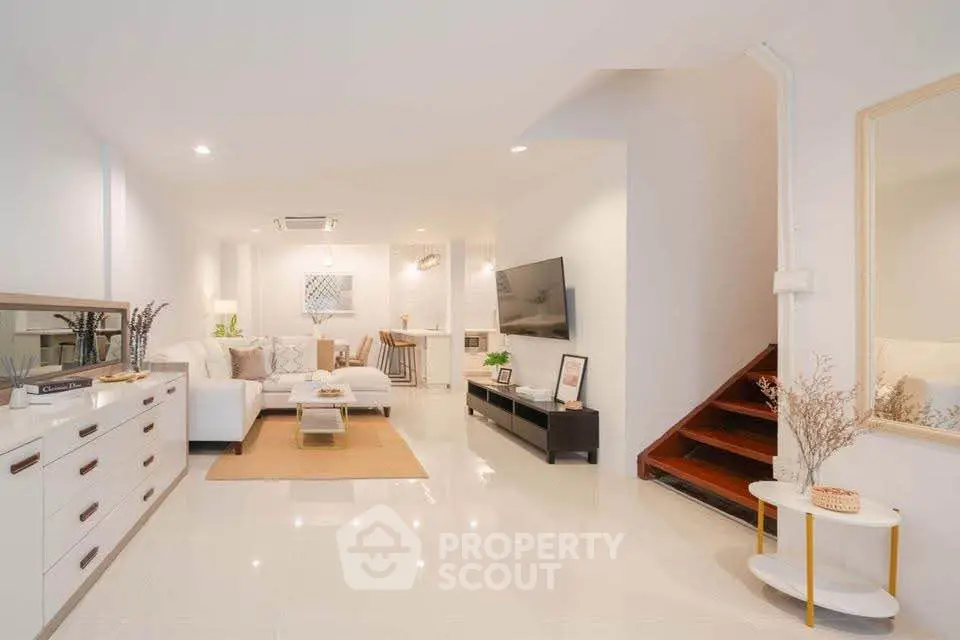 Spacious modern living room with elegant decor and staircase, perfect for stylish urban living.