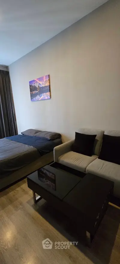 Modern studio apartment with cozy bed and stylish sofa, perfect for urban living.