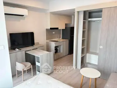 Modern studio apartment with compact kitchen and stylish furniture, perfect for urban living.