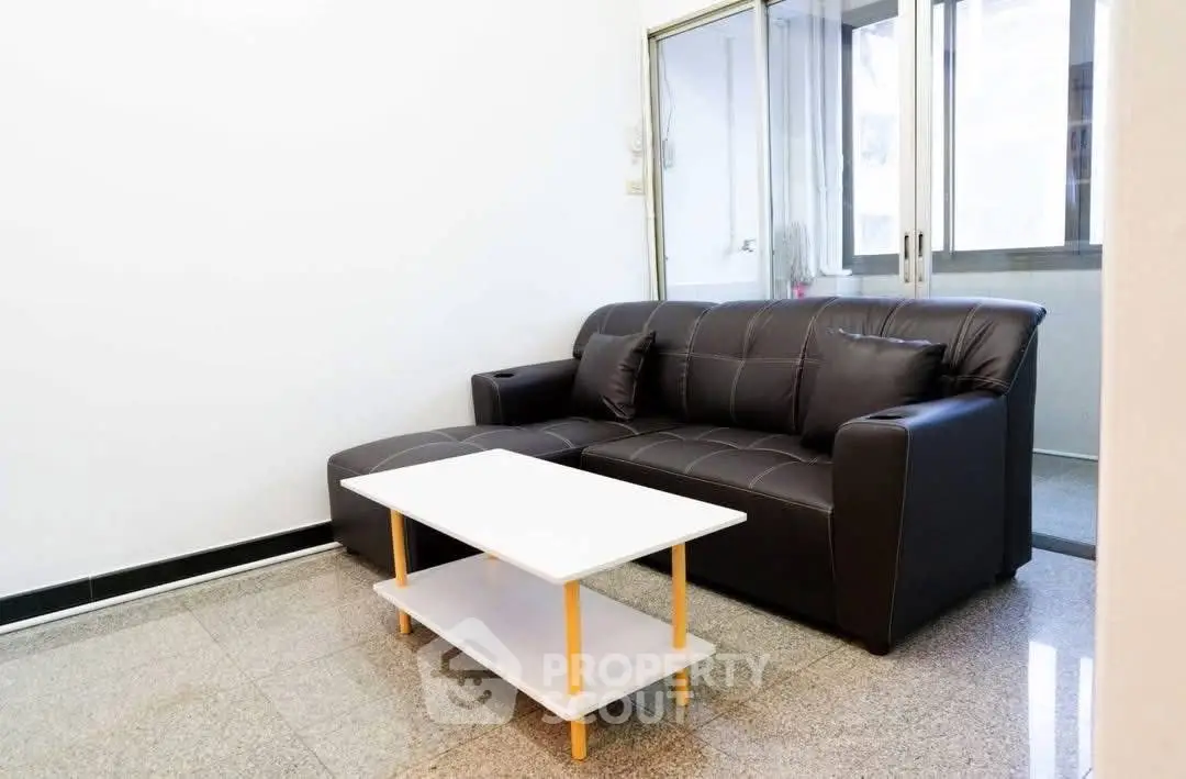 Modern living room with sleek black sofa and minimalist coffee table