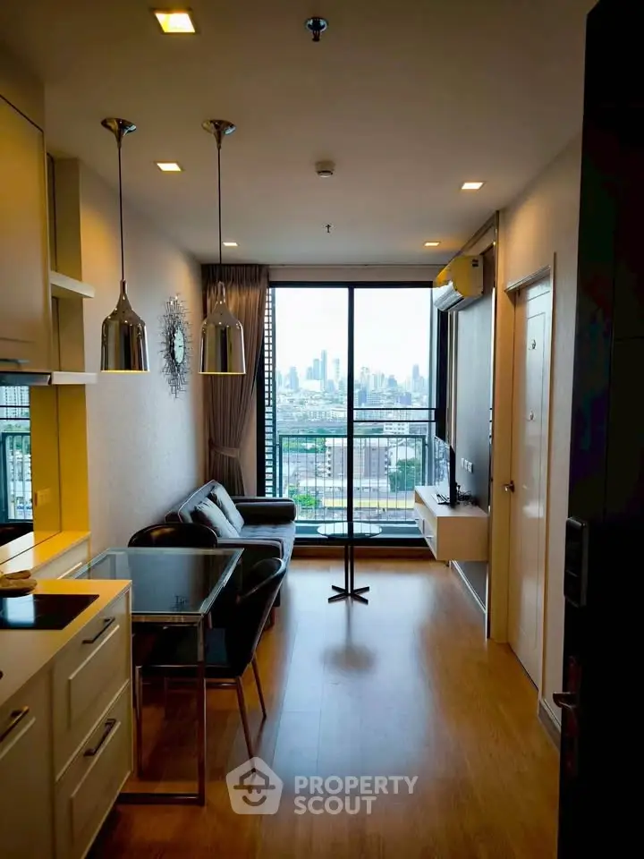 Modern living room with city view, open kitchen, and stylish decor in a high-rise apartment.