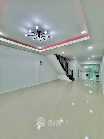 Spacious modern living room with sleek staircase and contemporary lighting