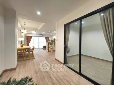 Spacious open-plan living and dining area with modern decor and large windows