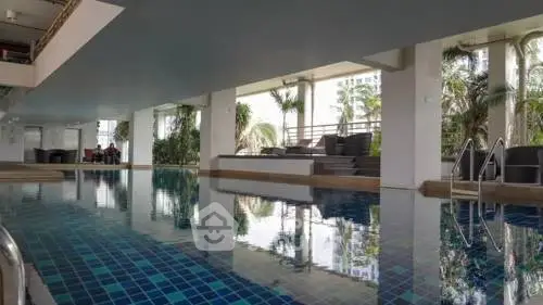 Luxurious indoor pool with modern design and lush greenery, perfect for relaxation and leisure.