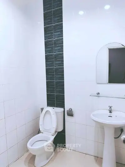 Modern bathroom with sleek white tiles and pedestal sink