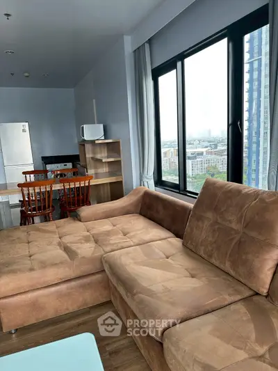 Spacious living room with modern furniture and city view, perfect for urban living.
