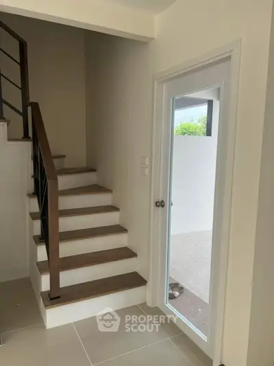 Modern staircase with glass door leading to outdoor patio
