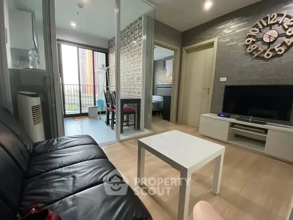 Modern living room with black leather sofa and stylish wall clock