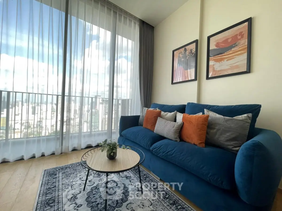 Stylish living room with blue sofa, vibrant cushions, and city view through large windows.